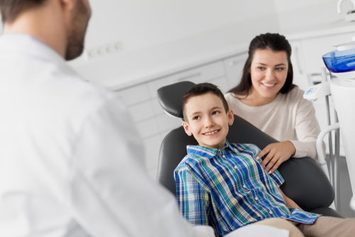 kid grins parent child dental visit